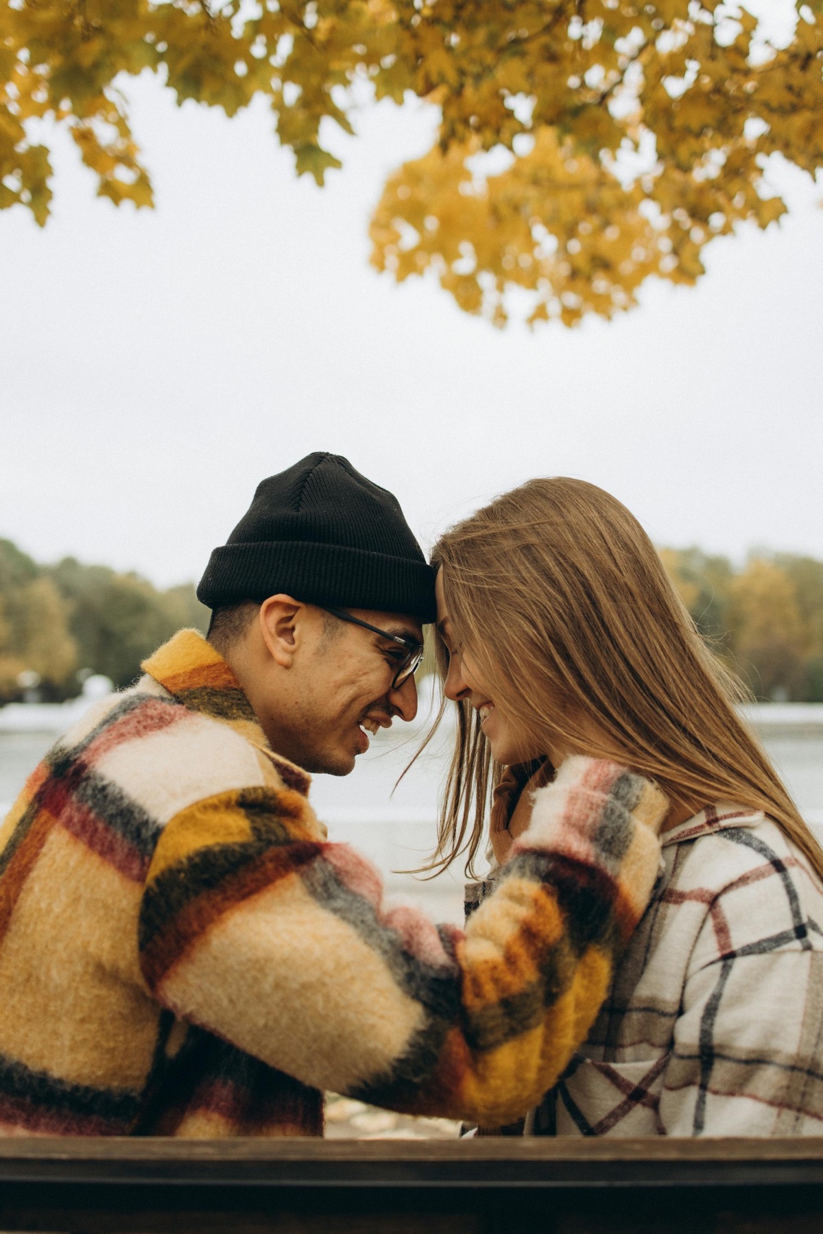Two people sharing a warm moment outdoors in autumn